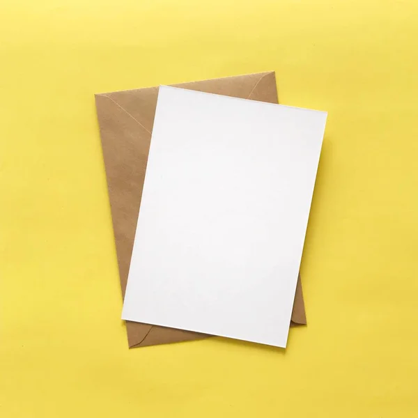 Envelope de cartão postal branco em branco no fundo amarelo — Fotografia de Stock