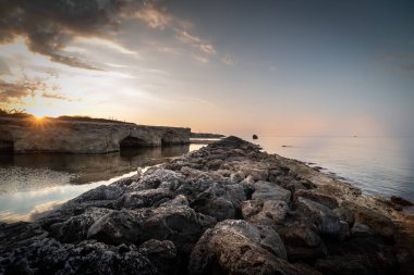 Cirica Körfezi'nde kayalıklarda yükselen güneş, Sicilya, İtalya