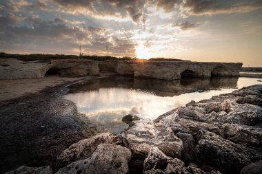 Cirica Körfezi'nde kayalıklarda yükselen güneş, Sicilya, İtalya