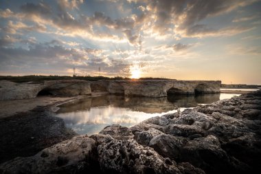 Cirica Körfezi'nde kayalıklarda yükselen güneş, Sicilya, İtalya