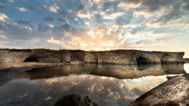 Cirica Körfezi'nde kayalıklarda yükselen güneş, Sicilya, İtalya