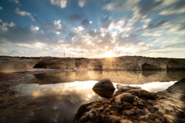 Cirica Körfezi'nde kayalıklarda yükselen güneş, Sicilya, İtalya