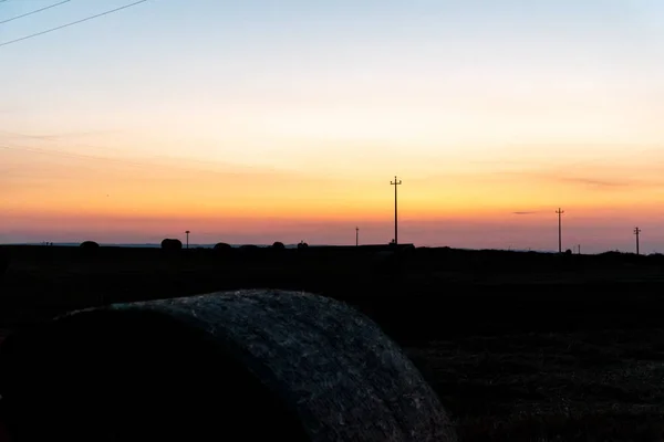 Salida del sol sobre un campo de trigo con fardos — Foto de Stock