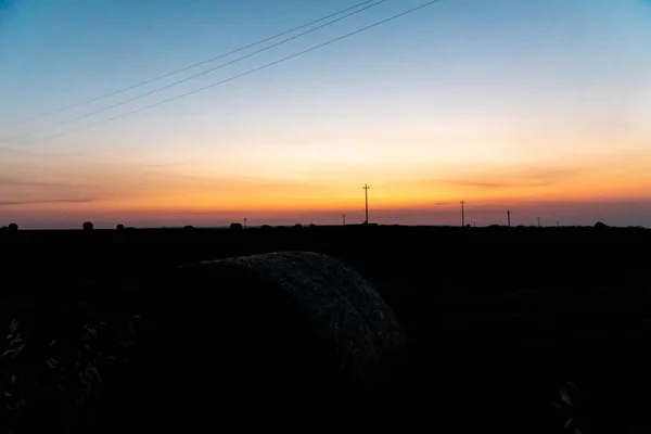 Salida del sol sobre un campo de trigo con fardos — Foto de Stock