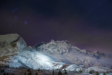 Gece vakti karla kaplı dağ manzarası 