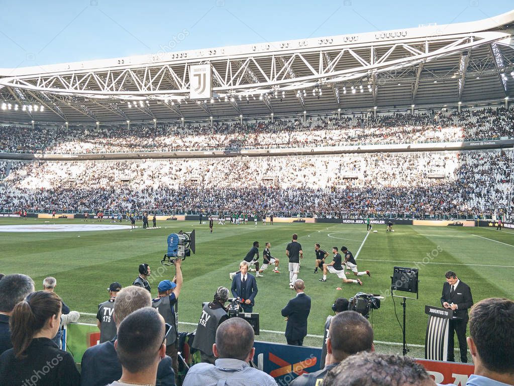 Turin, Italy - September 29, 2018: Players training before the match at the Allianz Stadium, the field where Juventus plays its home matches. The shot is taken before the Serie A match Juve-Napoli with people waiting for the match to start