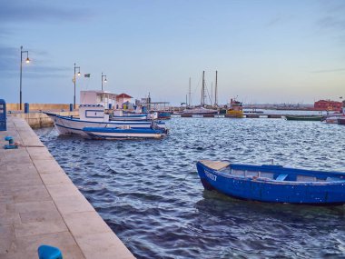 Sicilya 'da gün batımında Marzamim limanında tekneler.