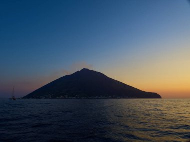 Gün batımında tekneden volkanı vurmak.