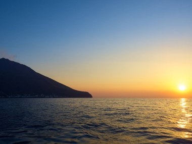 Gün batımında tekneden volkanı vurmak.