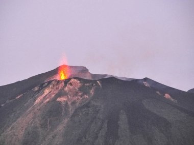 Volkandan çıkan magma, patlama, duman ve lapilli patlaması.