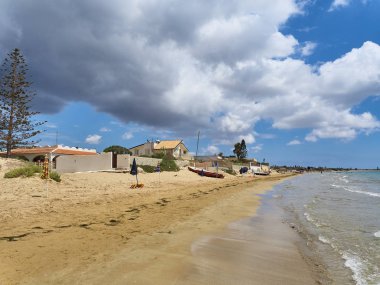 Sicilya'da bir sahil üzerinde görkemli güneşli ve bulutlu karışık gökyüzü
