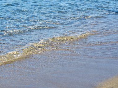 Yaz güneşli bir günde Syracuse yakınlarındaki güzel tropikal San Lorenzo plajda kum üzerinde dalgalar Shot