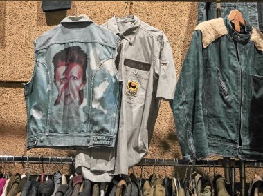 Milano, İtalya - 14 Ekim 2018: Standda elbiselerin duvardan çekimi. Doğu Pazarı Milano'da ayda bir kez yönetilen bir vintage kapalı pazar. Onlar vintage elbiseler, güneş gözlüğü, vinil, yiyecek, içecek, mobilya ve benzeri satmak