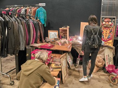 Milano, İtalya - 14 Ekim 2018: İnsanlar Milano'daki vintage East Market'ten alışveriş yapıyor. Doğu Pazarı Milano'da ayda bir kez yönetilen bir vintage kapalı pazar. Onlar vintage elbiseler, güneş gözlüğü, vinil, yiyecek, içecek, mobilya ve benzeri satmak