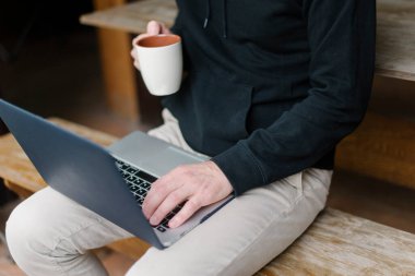 Bir fincan kahveyle bir erkeğin elleri.