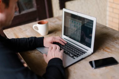 Bir fincan kahveyle bir erkeğin elleri.