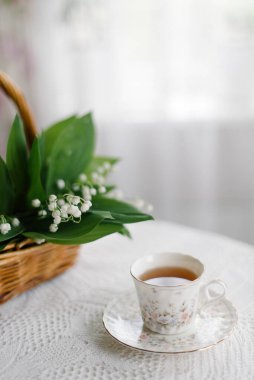 Sepetteki vadi zambakları ve bir fincan çay.