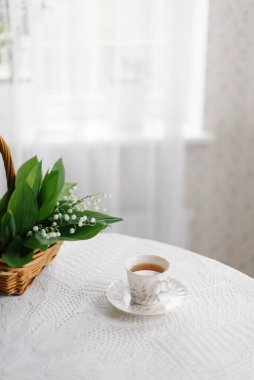 Sepetteki vadi zambakları ve bir fincan çay.