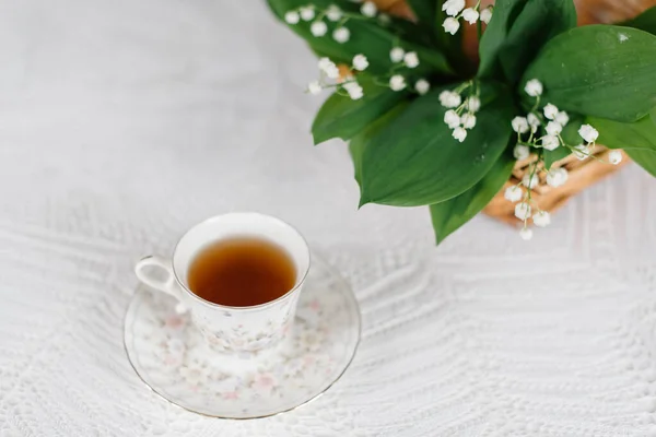 Sepetteki vadi zambakları ve bir fincan çay.