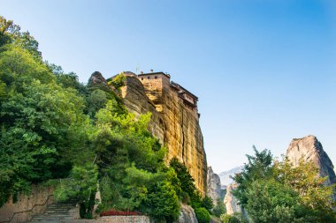 Meteora Yunanistan Manastırı. Göz kamaştırıcı panoramik manzara. Bulutlu destansı mavi gökyüzüne karşı dağlar ve yeşil orman manzarası. Unesco miras nesnesi.
