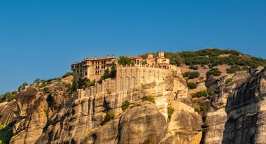 Meteora Yunanistan Manastırı. Göz kamaştırıcı panoramik manzara. Bulutlu destansı mavi gökyüzüne karşı dağlar ve yeşil orman manzarası. Unesco miras nesnesi.