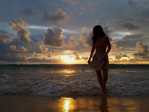 美しい夕日のビーチの背景に若い女性 ロイヤリティフリーのストック写真