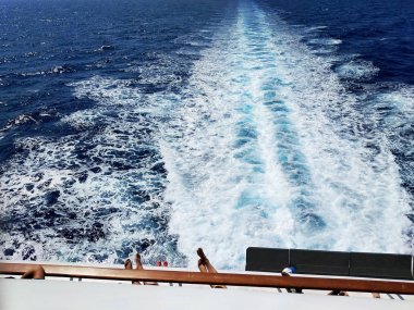 Yat yolu manzaralı hızlı hareket eden yat arkasında ayaklar. Lüks yaz tatili konsepti.