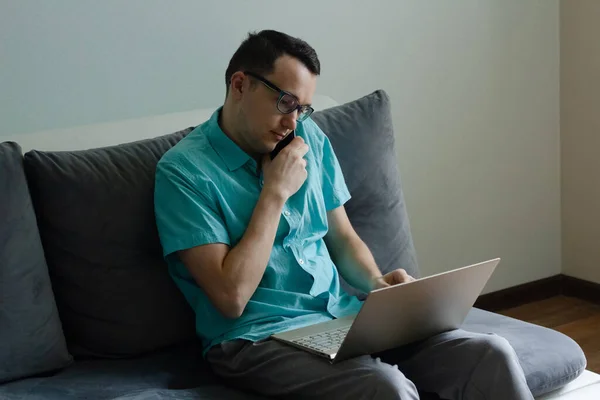 Jeune Homme Dans Des Lunettes Parlant Téléphone Regardant Sur Écran Photo De Stock