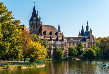Budapeşte / Macaristan - 6 Ekim 2018: Vajdahunyad Kalesi göl kenarından görüntülendi. 1896 yılında Milenyum Sergisi'nin bir parçası olarak inşa edilmiş ve şimdi Macar Tarım Müzesi'ne ev sahipliği yapmaktadır..