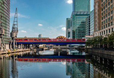 Londra / İngiltere - 27 Ağustos 2019: Docklands Hafif Demiryolu, Canary Wharf Development'da Kuzey Rıhtımı'nın sularına yansıdı.