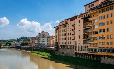 Floransa / İtalya - 26 Mayıs 2018: Lungarno degli Acciaiuoli de dahil olmak üzere Arno Nehri 'nin kuzey kıyısındaki eski binaların manzarası. Arka plandaki St. Trinity Köprüsü..