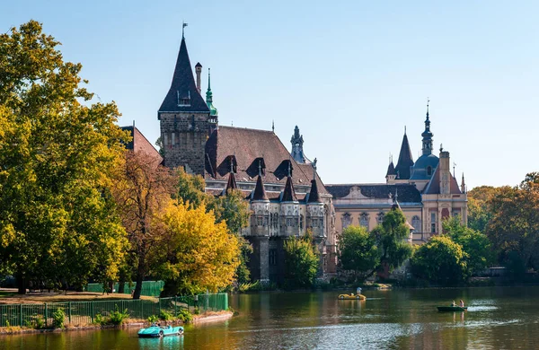 Budapeşte / Macaristan - 6 Ekim 2018: Vajdahunyad Şatosu göl kenarından, ziyaretçi botu ise gölde görüldü. 1896 'da inşa edilen bina şimdi Macar Tarım Müzesi' ne ev sahipliği yapıyor.. 