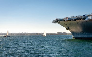 Yelkenli tekneler ve UUS Midway 'in pruvası ile San Diego Körfezi manzarası.