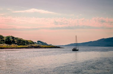 Bir yelkenli Aline Gölü 'nü geride bırakıyor. Loch Aline, Morvern, Lochaber, İskoçya 'da bulunan küçük bir tuzlu su gölüdür..