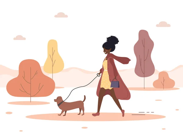 Podzimní pozadí. Mladá africká žena chodí se psem lesem. Koncept šťastná dívka v hnědém kabátě s jezevčíkem nebo pudlem. Vektorová ilustrace v plochém stylu. — Stockový vektor