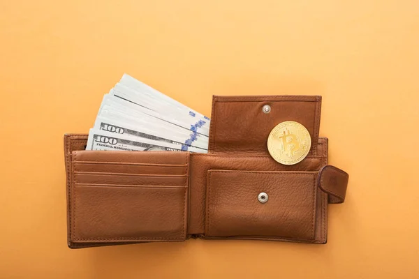Bitmince, sto dolarových bankovek a kožená peněženka na oranžovém pozadí. — Stock fotografie