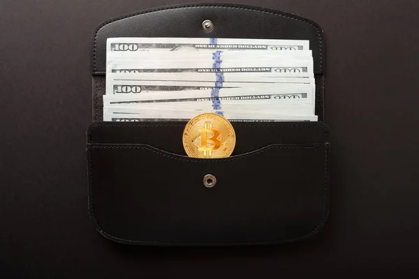 Bitcoin, hundra dollarsedlar och läder plånbok på den svarta bakgrunden. — Stockfoto