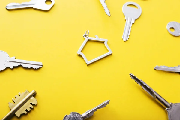 Sleutels en Trinket in vorm van huis in het midden op kleur achtergrond, Top View. — Stockfoto