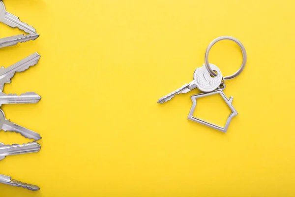 Hausschlüssel mit Schmuckstück auf farbigem Hintergrund, Draufsicht mit Kopierraum. — Stockfoto