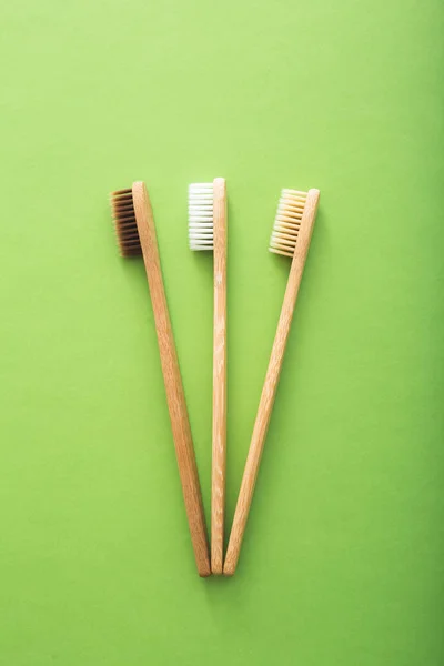Dental care with eco friendly bamboo toothbrush on green background top view. Zero waste and plastic free concept. — Stock Photo, Image