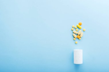 İlaç ilaç hapları ve şişe mavi arka plan üzerinde.