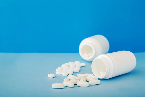 Pilules médicales blanches et comprimés se répandant hors d'une bouteille. Maquette bouteilles avec espace de copie . — Photo