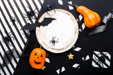 Cadılar Bayramı parti davetiyesi maket, kutlama. Çerçeve. Yarasalar, örümcekler, jack-o'-fener, yıldız, konfeti, kurdele ile Halloween süslemeleri kavramı. Düz döşeme, üst görünüm, siyah beyaz bac üzerinde kopya alanı