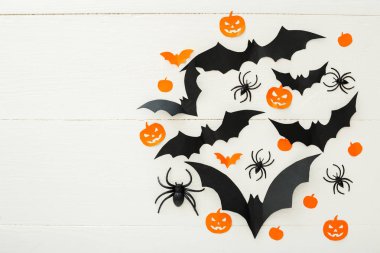Kağıt yarasalar, kabaklar, beyaz ahşap arka plan üzerinde örümcekler ile Halloween arka plan. Cadılar Bayramı tatil süslemeleri. Düz döşeme, üst görünüm, kopyalama alanı. Parti davetiyesi maket, kutlama.