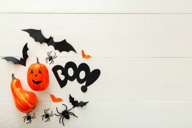 Kağıt yarasalar, örümcekler, beyaz ahşap arka plan üzerinde jack-o'-fener ile Halloween arka plan. Cadılar Bayramı tatil süslemeleri. Düz döşeme, üst görünüm, kopyalama alanı. Parti davetiyesi maket, kutlama.
