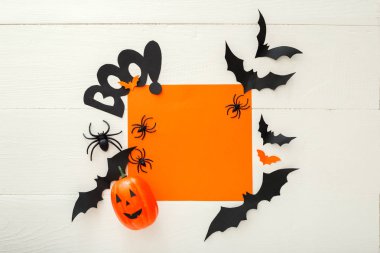 Kağıt yarasalar, örümcekler, beyaz ahşap arka plan üzerinde jack-o'-fener ile Halloween arka plan. Cadılar Bayramı tatil süslemeleri. Düz döşeme, üst görünüm, kopyalama alanı. Parti davetiyesi maket, kutlama.