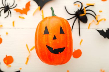 Jack-o'-lanter, kağıt yarasalar, örümcekler, beyaz ahşap arka plan konfeti ile Halloween arka plan. Cadılar Bayramı tatil süslemeleri. Düz yatıyordu, üstten bak. Parti davetiyesi maket, kutlama.