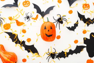 Jack-o'-lanter, kabaklar, kağıt yarasalar, örümcekler, beyaz ahşap arka plan konfeti ile Halloween arka plan. Cadılar Bayramı tatil süslemeleri. Düz yatıyordu, üstten bak. Parti davetiyesi maket, kutlama.