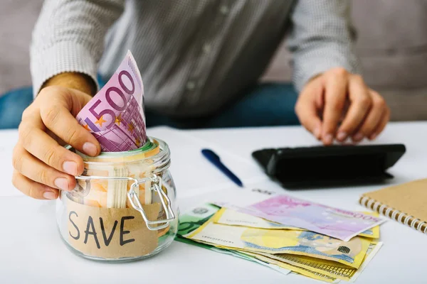 Az emberek kezét üzembe euro Bills bankjegy egy üvegpalackot megtakarítás. Ember csinál a számvitel. Kisvállalkozás: betét-és hitelnyújtás, kamatláb-csökkentés. — Stock Fotó