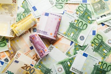 Avro banknotları etrafa saçılmış avro paralarıyla dolu. İş, finans, tasarruf, bankacılık konsepti, döviz kuru. Çerçeve, kopyalama alanı, üst görünüm.